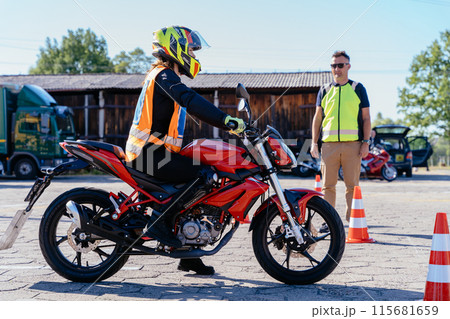 Concept of motorcycle school of driving. Student learning how to drive motorcycle with instructor. 115681659