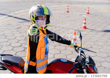 Student L driver showing motorcycle driving license as successfully finished riding exams. Concept of motorcycle school of driving. 115681700