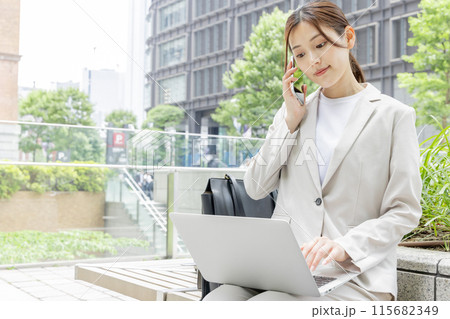ベンチに座って仕事をする若い女性 ベンチに座って仕事をする若い女性 115682349