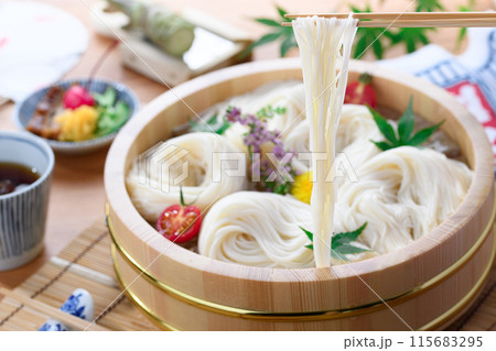 桶に入れたそうめんを箸で持ち上げる (素麺) 桶に入れたそうめんを箸で持ち上げる (素麺) 115683295