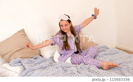 Girl yawning while stretching on bed 115683356