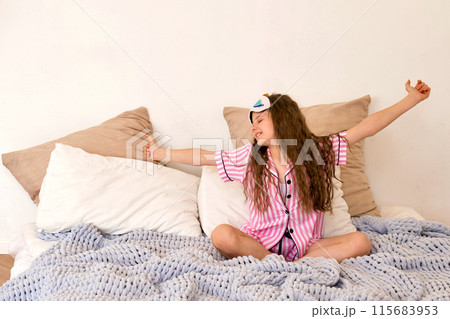 Young girl stretching on bed in bedroom, waking up. Young girl stretching on bed in bedroom, waking up. 115683953