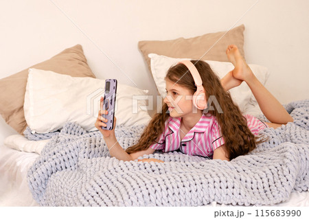 Girl taking selfie with smartphone in bedroom. 115683990