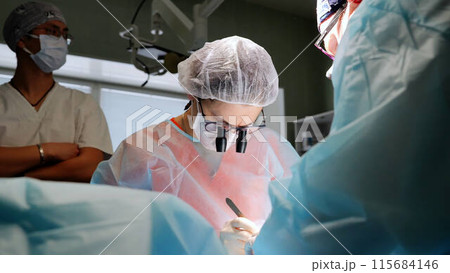 Doctor surgeon with dedicated team operates on patient teamwork modern medicine. This scene reflects life-saving efforts and critical importance of surgical profession in healthcare. 115684146