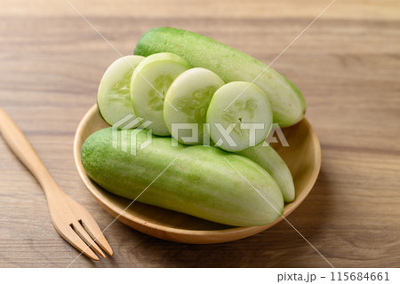 Sliced cucumber on wooden plate, Organic vegetable, Food ingredient Sliced cucumber on wooden plate, Organic vegetable, Food ingredient 115684661