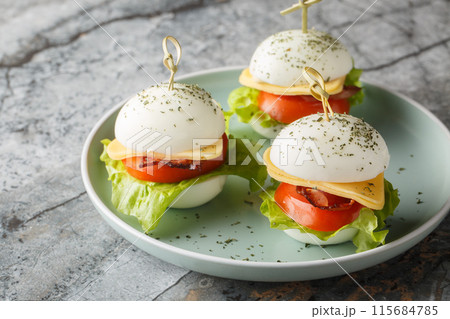 Easter Egg Appetizer Skewers with cheese, bacon, tomato and lettuce close-up in a plate. Horizontal 115684785