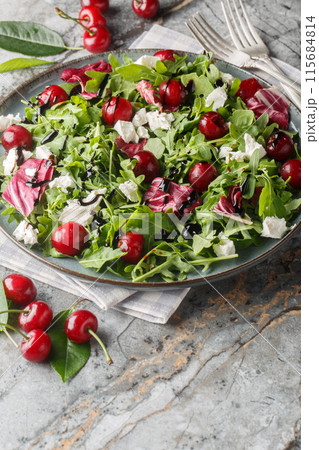 Summer salad with berries cherry, arugula, chicory and feta cheese dressed with balsamic sauce close-up in a plate. Vertical Summer salad with berries cherry, arugula, chicory and feta cheese dressed with balsamic sauce close-up in a plate. Vertical 115684814