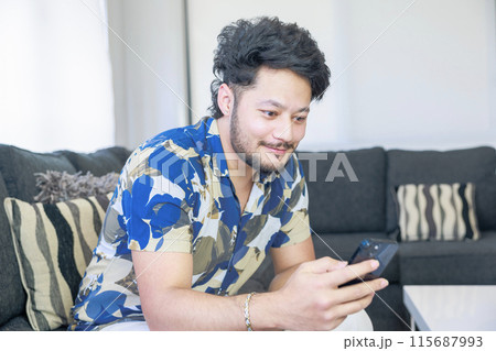 スマートフォンを見る若い男性 スマートフォンを見る若い男性 115687993