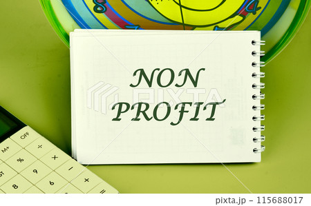 Accounting concept. Text NON PROFIT on a notepad on the background of a clock next to a calculator 115688017