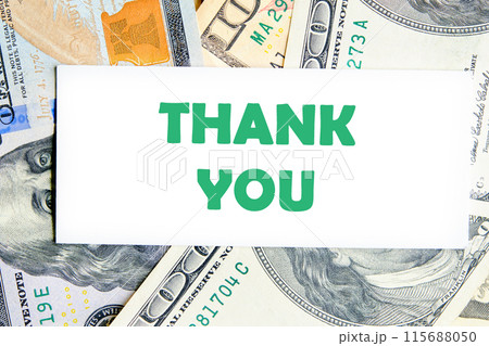 Expressing gratitude, acknowledgment and appreciation. Thank you message on a white business card against a background of dollar bills 115688050