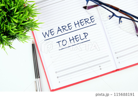 WE ARE HERE TO HELP CONCEPT written in an open business notebook on a blank sheet WE ARE HERE TO HELP CONCEPT written in an open business notebook on a blank sheet 115688191