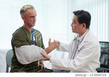 Doctor Putting Bandage On Arm Of Soldier 115688728