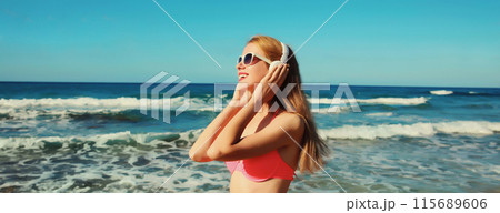 Summer vacation of relaxed happy woman enjoying listening to music with headphones on beach at sea 115689606