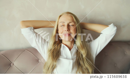 Happy relaxed middle aged woman enjoying at home sitting on the couch in living room Happy relaxed middle aged woman enjoying at home sitting on the couch in living room 115689638