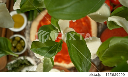 Delicious pizza with flying ingredients from above. Delicious pizza with flying ingredients from above. 115689990