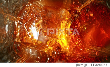 Closeup of ice cube inside glass of whiskey. Closeup of ice cube inside glass of whiskey. 115690033