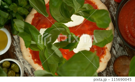 Delicious pizza with flying ingredients from above. Delicious pizza with flying ingredients from above. 115690045