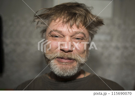 a man with a beard and messy hair is making a funny face 115690070