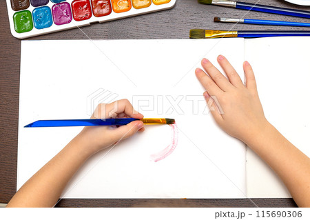 small child draws with pastel crayons on white table. fathers day 115690306