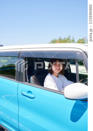 車に乗る若い女性 115690860
