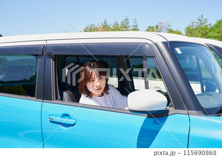 車に乗る若い女性 115690868