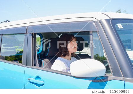 車に乗る若い女性 115690995