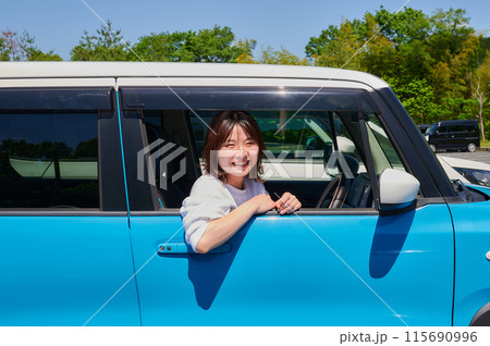 車に乗る若い女性 115690996