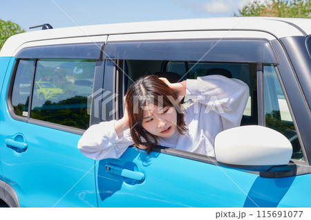車に乗って頭を抱える女性 車に乗って頭を抱える女性 115691077