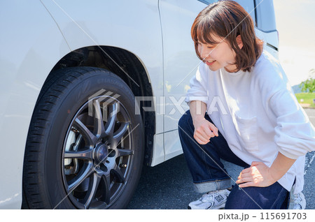 車のタイヤを確認する女性　パンク　空気圧 115691703