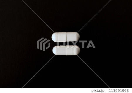 Pills. White pills, medical capsules. Isolated on a black background. An allergy pill, antibiotics, supplements. Medicine, healthcare concept. Virus(viral) and flu diseases. High quality photo 115691968