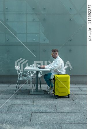Happy traveling Caucasian man in stylish clothes uses mobile smartphone and laptop, checking trip destination on Internet. Male waiting at flight gates for plane boarding, smiling have a vacation trip Happy traveling Caucasian man in stylish clothes uses mobile smartphone and laptop, checking trip destination on Internet. Male waiting at flight gates for plane boarding, smiling have a vacation trip 115692275