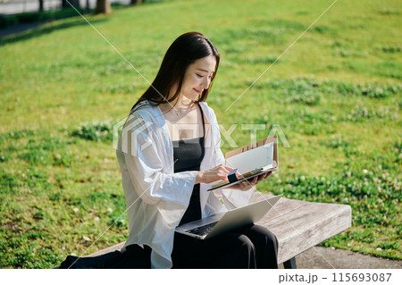 手帳を見てスケジュールを確認する若い女性 115693087