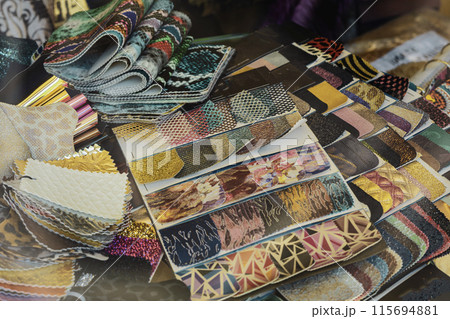 Close-up of a table covered in various Leather swatches are organized by color and pattern 115694881