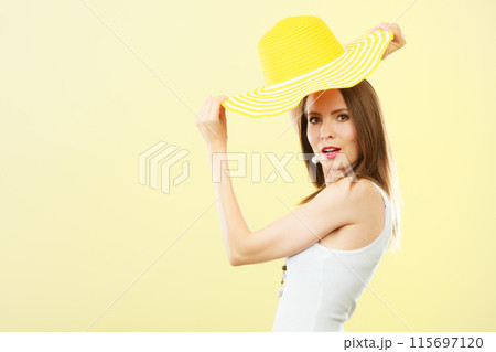 Woman in big yellow summer hat. Woman in big yellow summer hat. 115697120