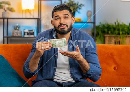 Hispanic man upset over insufficient amount of money showing one dollar banknote bankruptcy poverty 115697342