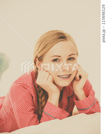Smiling woman lying in bed Smiling woman lying in bed 115698129