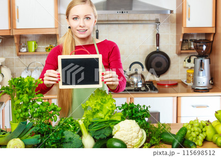 Woman having green vegetables holding board 115698512