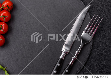 Empty round slate plate for template on the black background 115698645