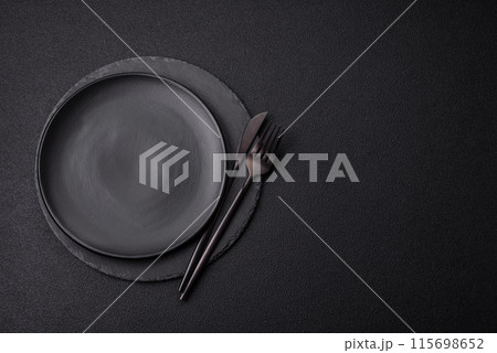 Empty round slate plate for template on the black background 115698652