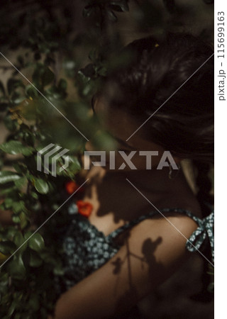 Artistic portrayal of woman in natural setting, lit by sunlight and shadows, showing beauty Artistic portrayal of woman in natural setting, lit by sunlight and shadows, showing beauty 115699163