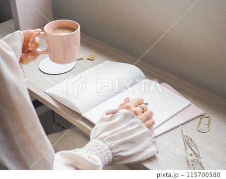 コーヒーを飲みながら読書をする女性 115700580