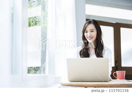 カフェでテレワークをする若い女性 カフェでテレワークをする若い女性 115701156