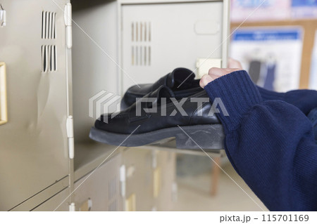 学校の下駄箱に靴を入れる女子高生手元 115701169
