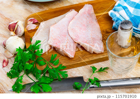 Raw rockfish fillet with condiments, food preparation 115701910