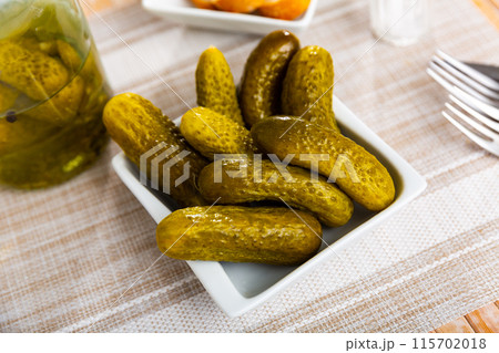 Marinated cucumbers pods served on plate 115702018