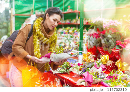 Woman choosing christmas decorations at fair 115702210