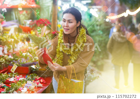 Woman choosing christmas decoration at street sale 115702272
