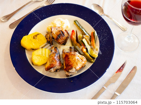 Roasted rabbit served with vegetable garnish 115703064