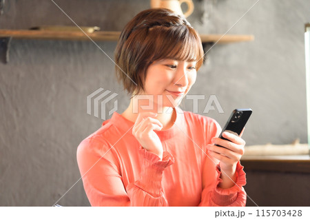 カフェでスマホを見る女性　 115703428