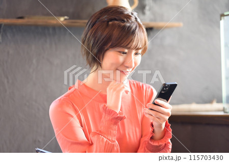 カフェでスマホを見る女性 カフェでスマホを見る女性 115703430